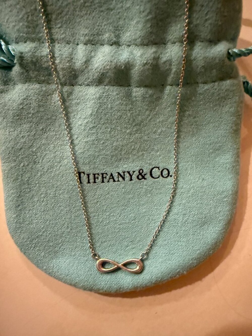 Tiffany & Co. sterling silver necklace featuring the iconic Infinity pendant des